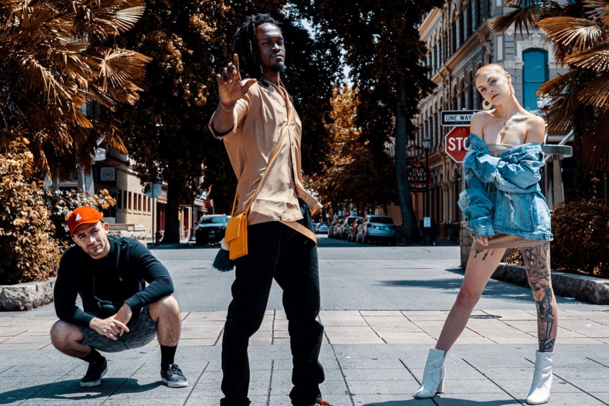 Outdoor fashion shoot featuring stylish models posing confidently in an urban setting.